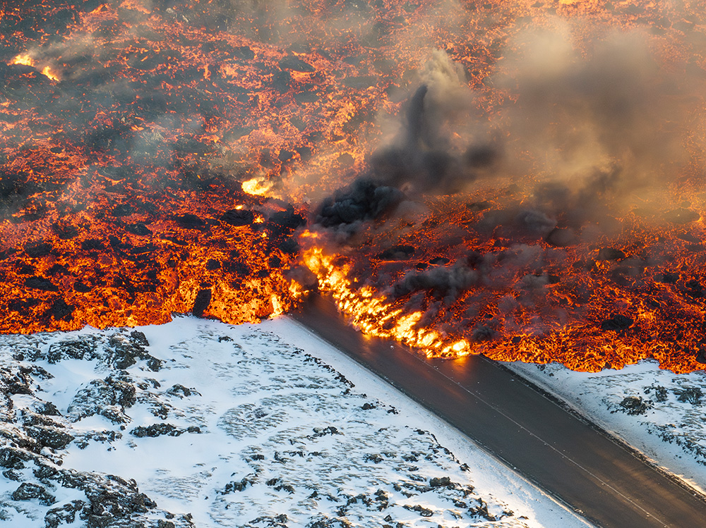 Photojournalism. Lava crosses the road to Blue Lagoon, Iceland. Marco Di Marco