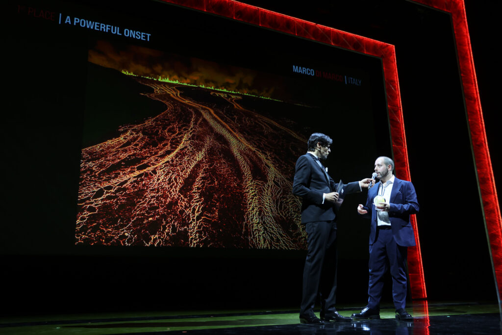 Marco Di Marco receiving the 1st Place award at the 2026 Siena International Photo Awards, with A Powerful Onset displayed on stage
